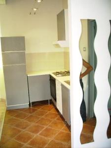 a kitchen with white cabinets and a tile floor at Glicine in Miasino +7 photos