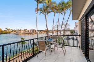 ein Balkon mit Tisch und Stühlen und Blick auf das Wasser in der Unterkunft Refined Surfers Paradise Escape with Captivating Night City Views in Gold Coast