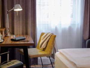 a bedroom with a desk and a bed and a desk with a chair at Mercure Hotel Berlin City in Berlin +140 photos