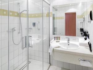 a bathroom with a sink and a shower at Novotel Hildesheim in Hildesheim