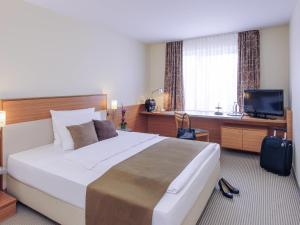 a hotel room with a large bed and a television at Mercure Hotel Mannheim am Rathaus in Mannheim +78 photos