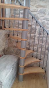 a metal spiral staircase with wooden steps next to a bed at Dalmatinisches Haus In Der Altstadt Von Split in Split +18 photos