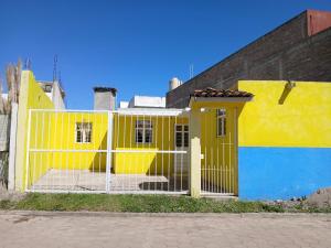 Un edificio amarillo y azul con una puerta. en CASA ACOGEDORA, en Chignahuapan
