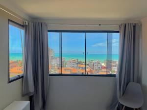 a room with a window with a view of the ocean at Pousada Maresia in Maragogi