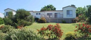 uma casa com muitas flores no quintal em Lookout Holiday Units em Lakes Entrance