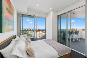 a bedroom with a bed and a view of the ocean at Cityview Escape Poolside Living near CBD and Beach in North Wollongong +28 photos