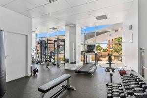 a gym with cardio equipment and a large window at Cityview Escape Poolside Living near CBD and Beach in North Wollongong