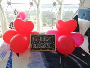 a bunch of red heart balloons with a sign on a table at Cabaña San Martin in Guatavita