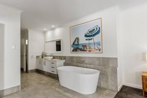 ein Badezimmer mit einer Badewanne, einem Waschbecken und einem Sonnenschirm in der Unterkunft Sundrift - Sophisticated Beachside Retreat with Pool in Dunsborough + 8 Fotos