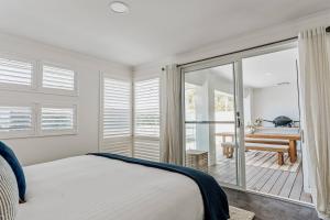 ein Schlafzimmer mit einem Bett und einem Balkon in der Unterkunft Sundrift - Sophisticated Beachside Retreat with Pool in Dunsborough