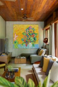 a living room with a couch and a painting on the wall at Villa 21 in Itacaré