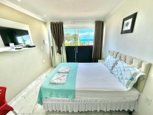 a bedroom with a large bed with a window at Pousada Maresia in Maragogi