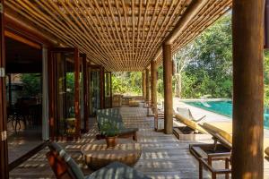 an outdoor patio with chairs and a swimming pool at Villa 21 in Itacaré
