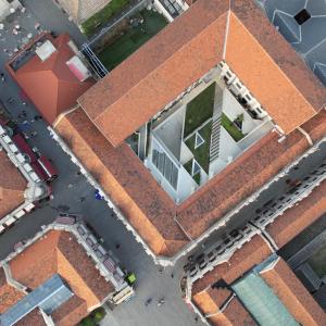 een raam met uitzicht op een bakstenen gebouw bij 烟台朝阳文保艺术酒店 in Yantai