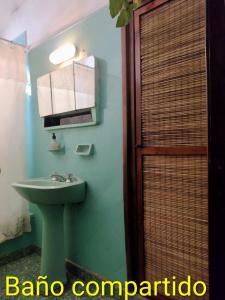a bathroom with a green sink and a mirror at Hospedaje in Salta