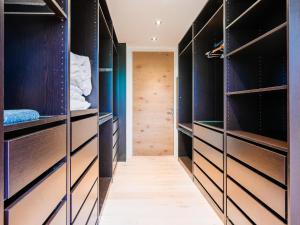 a walk in closet with dark wood and blue walls at Alpin Chalet ARTE in Söll