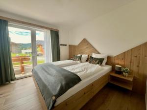a bedroom with a large bed and a large window at Grebenzen Lodge Edelweiss in Sankt Lambrecht