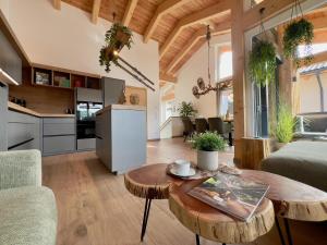 a living room with a table and a kitchen at Grebenzen Lodge Edelweiss in Sankt Lambrecht