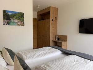 a bedroom with a bed and a flat screen tv at Grebenzen Lodge Edelweiss in Sankt Lambrecht