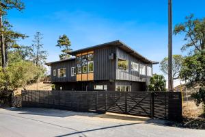 Ein schwarzes Haus mit einem Zaun davor. in der Unterkunft Spectacular Bolinas Oceanfront Retreat in Bolinas