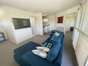 Mambo #5 Double Storey Holiday Home في أغنيس ووتر: غرفة معيشة بها كنب ازرق وتلفزيون +22 صورة