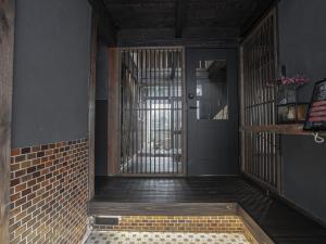 a room with a door and aoyer with a brick wall at 旅館 なおみ in Toba