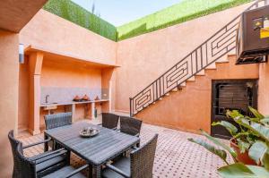 un patio avec une table et des chaises et un escalier dans l'établissement Luxury 4-ROM Villa with private Heated pool in Akenza ,free Airport transport service, à El Rhechat