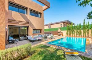 une cour arrière avec une piscine et une maison dans l'établissement Luxury 4-ROM Villa with private Heated pool in Akenza ,free Airport transport service, à El Rhechat