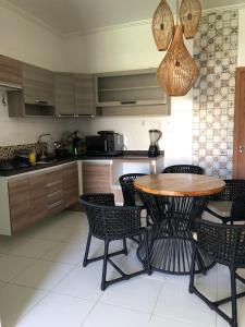 a kitchen with a table and chairs in a kitchen at Monte Carlo Residencial in Valença