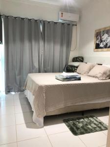 a bedroom with a bed with a gray curtain at Monte Carlo Residencial in Valença