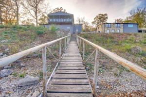 a wooden bridge leading to a house on a hill at Lakefront Eucha Escape with Views and Boat Slip! in Eucha