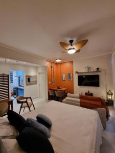 a living room with a couch and a tv at AptoVistamarArtachoJuradoComRoupaCamaBanho in Santos