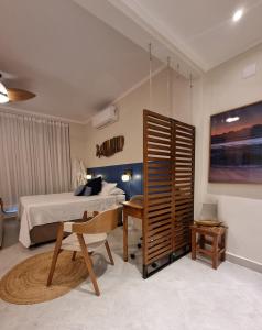 a bedroom with a bed and a desk and a table at AptoVistamarArtachoJuradoComRoupaCamaBanho in Santos