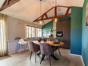 une cuisine et une salle à manger avec une table et des chaises en bois dans l'établissement Reggezicht, à Hellendoorn