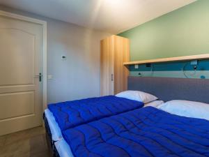 - une chambre avec 2 lits et une couette bleue dans l'établissement Reggezicht, à Hellendoorn