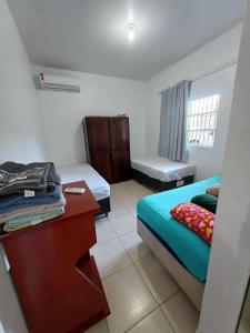 a small room with two beds and a table at Apartamento - Anthurium in Joinville