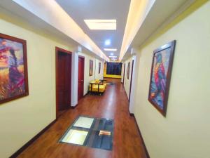 a hallway with paintings on the walls and a glass floor at Hotel Casa Santiago in Estación El Salto