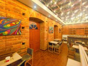 a room with a brick wall with tables and chairs at Hotel Casa Santiago in Estación El Salto