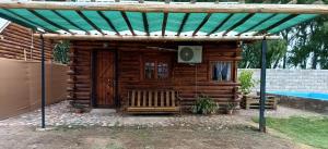 a wooden cabin with a bench under a roof at Cabañas Rústicas Entre Montañas in Tunuyán +5 photos