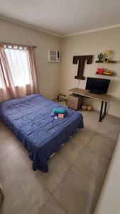 Un dormitorio con una cama azul en una habitación. en Quincho Sauco en Colonia Benitez, en Colonia Benítez