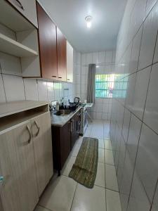a kitchen with wooden cabinets and a sink in it at Apartamento - Anthurium in Joinville +1 photo