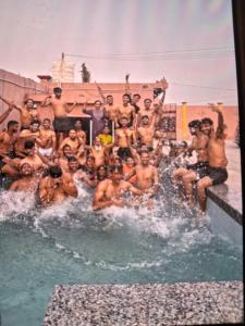 a group of men posing for a picture in a swimming pool at Veddaya Farm in Ghaziabad