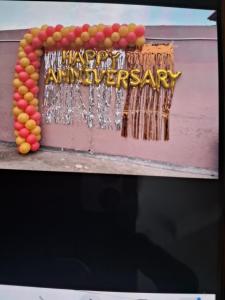 a sign that says happy anniversary on a wall at Veddaya Farm in Ghaziabad