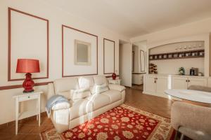 a living room with a white couch and a red rug at Casa Nizza D'Oro in Castelnuovo +72 photos