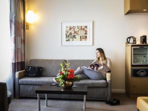 a woman sitting on a couch in a living room at Novotel Reading Centre in Reading +104 photos