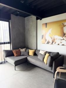 a living room with a couch and a painting on the wall at Upscale 2BR 2BA Apt w incredible Mountain Views in Oaxaca City