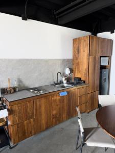 a kitchen with wooden cabinets and a sink at Upscale 2BR 2BA Apt w incredible Mountain Views in Oaxaca City +35 photos