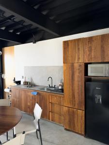 a kitchen with wooden cabinets and a sink and a table at Upscale 2BR 2BA Apt w incredible Mountain Views in Oaxaca City