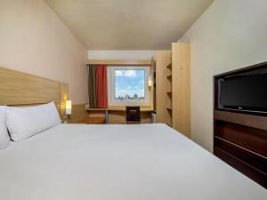 une chambre avec un grand lit et une télévision à écran plat dans l'établissement ibis Sao Paulo Interlagos, à São Paulo 67 autres photos