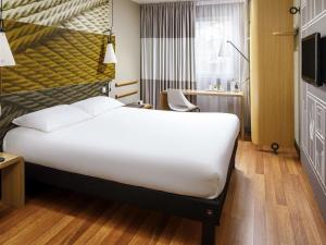 a hotel room with a large bed and a desk at ibis Bristol Centre in Bristol +90 photos